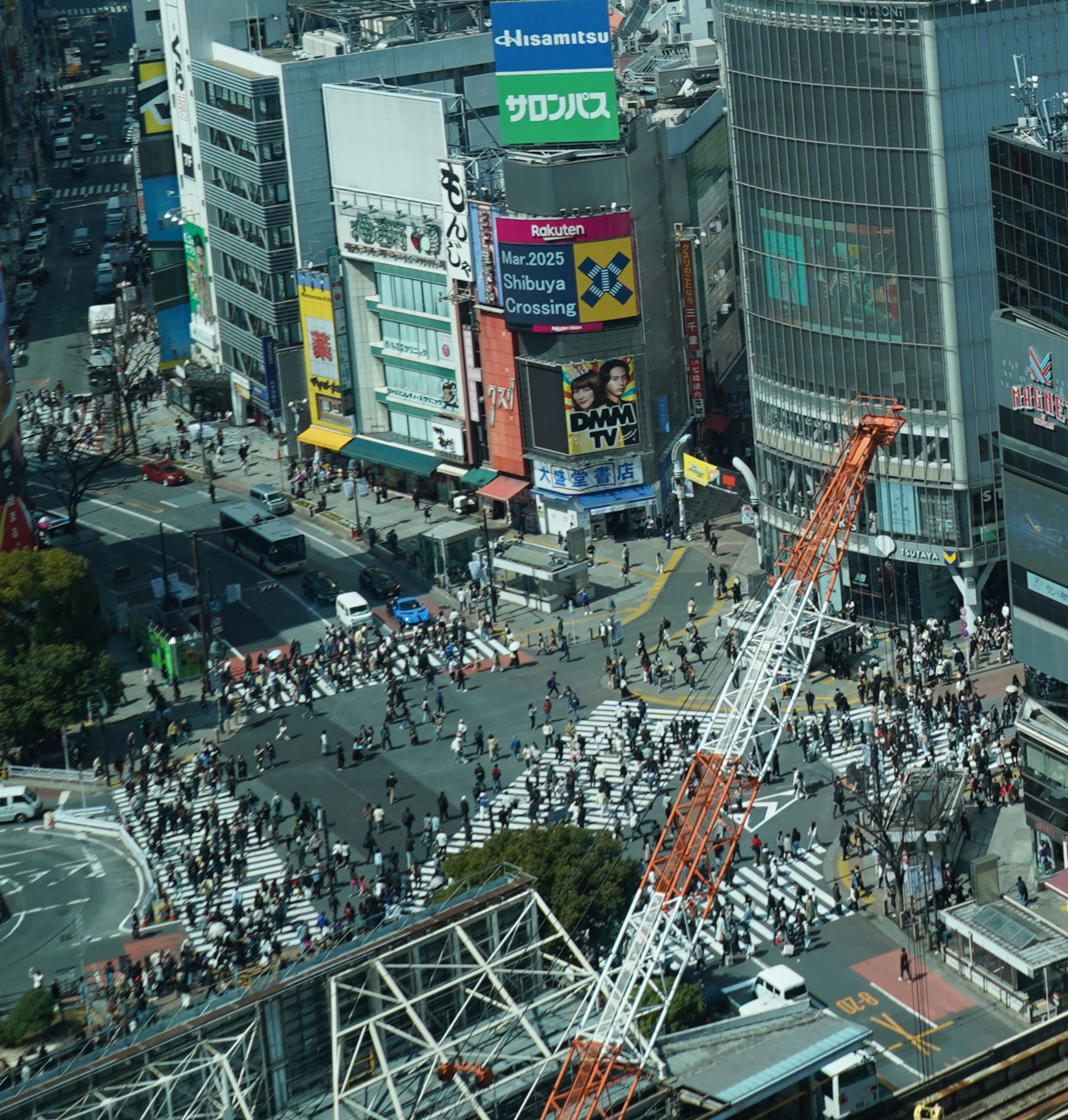 A picture from a high rise in Tokyo looking down at the crossing with a crane obscuring part.